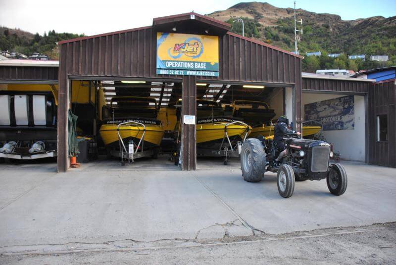 Jet boats in the garage being towed by a massey Ferguson tractor