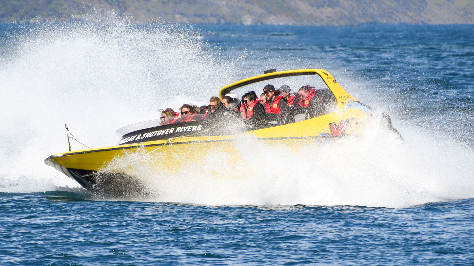Group of people in KJet jet boat in the lake just after a 360 degree spin in Queenstown New Zealand