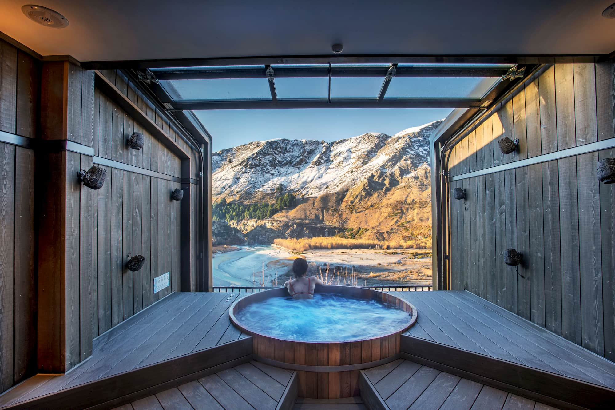 Person in spa at Onsen pools looking out at the mountains in Queenstown